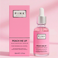 Pink Beauty Peach Me Up Niacinamide Serum shown with its pink box packaging and a clear glass dropper bottle filled with pink serum, set against a soft pink background.